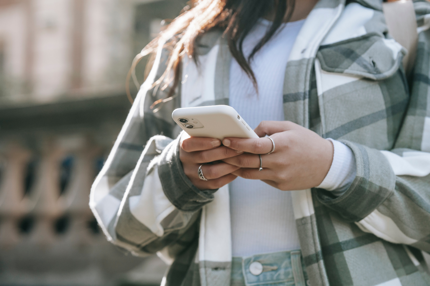 Unrecognizable female in street with cellphone